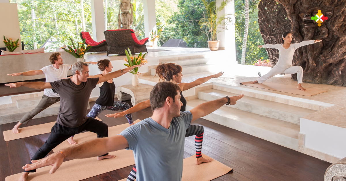 Guests practicing yoga on a resort deck at sunrise as part of a hotel wellness program